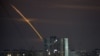 Russian rockets launched against Ukraine from Russia's Belgorod region streak across the sky at dawn in Kharkiv on March 24.