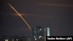 Russian rockets launched against Ukraine from Russia's Belgorod region streak across the sky at dawn in Kharkiv on March 24.