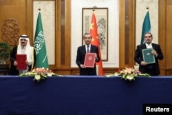 Vang Ji (u sredini) sa sporazumom iz marta 2023. u Pekingu sa sekretarom iranskog Vrhovnog vijeća za nacionalnu sigurnost, Alijem Šamhanijem (desno), i saudijskim državnim ministrom Musaadom bin Muhammadom al-Aibanom.