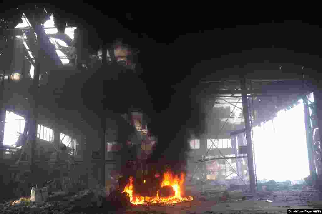 Горящий в аэропорту автомобиль. 16 октября 2014 года. После ожесточённых боёв за контроль над аэропортом в конце 2014-го — начале 2015 года он превратился в руины. Поддерживаемые Россией силы в конечном итоге восстановили контроль над объектом