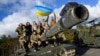 Ukrajinski vojnici poziraju sa zastavom na vrhu tenka Challenger 2 tokom obuke u kampu Bovington, blizu Woola na jugozapadu Velike Britanije, februar 2023. 