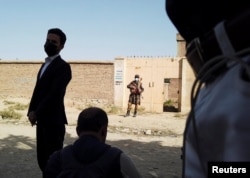 Talibanski vojnik čuva stražu ispred kuće u blizini skrovišta "Islamske države" koju su talibanske snage opkolile u sjevernom Kabulu, Afganistan, 4. oktobra 2021.