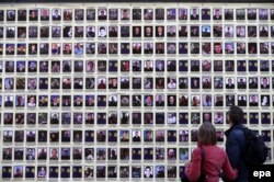 People walk past portraits in Kyiv of Ukrainian soldiers killed in the fighting in the east.