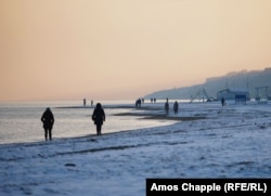Ljudi hodaju uz snijegom prekrivenu obalu na Azovskom moru u Mariupolju 6. februara.