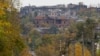 Мужчина толкает тележку в сторону разрушенного Мариуполя 29 октября 2022 года