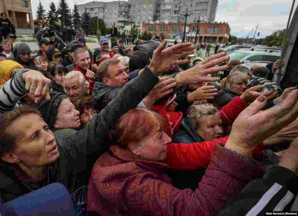 Lokalno stanovništvo se okuplja u blizini kamiona koji dijeli humanitarnu pomoć u oslobođenom gradu Balaklia.