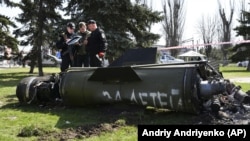 Ukrajinski vojnici stoje pored fragmenta rakete Točka-U sa natpisom na ruskom "Za djecu", na željezničkoj stanici u Kramatorsku, 8. aprila 2022.