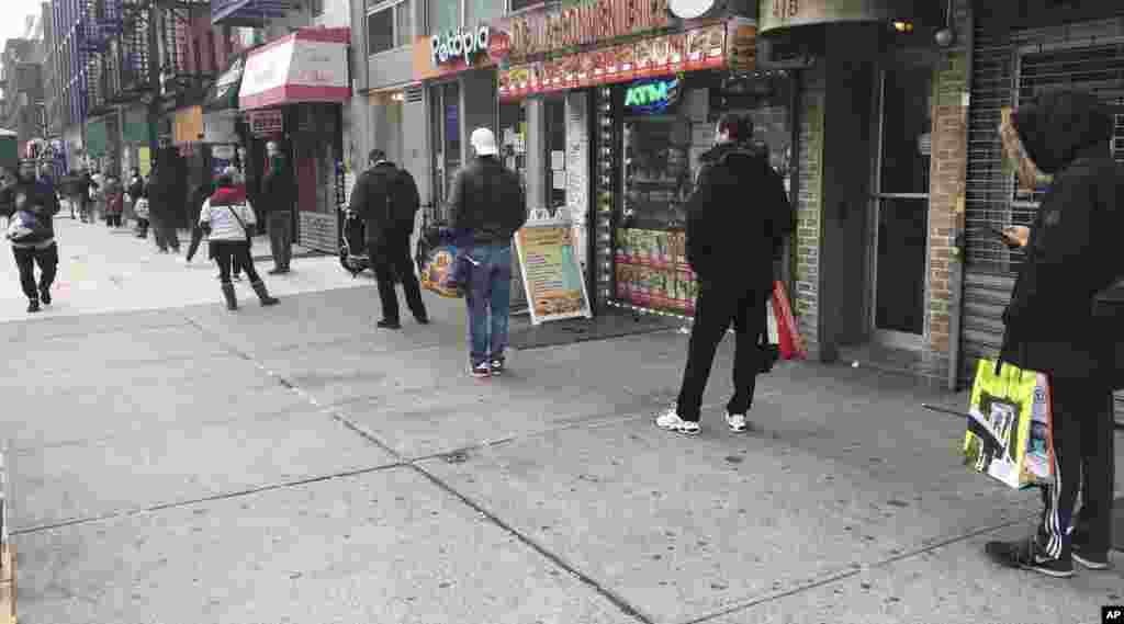 New Yorkers wear masks and maintain their distance in a long line outside Trader Joe&#39;s on March 25.