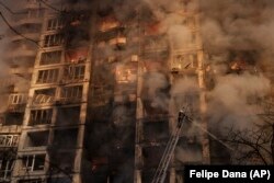 Ukrajinski vatrogasci u bombardovanoj stambenoj zgradi u Kijevu 15. marta.