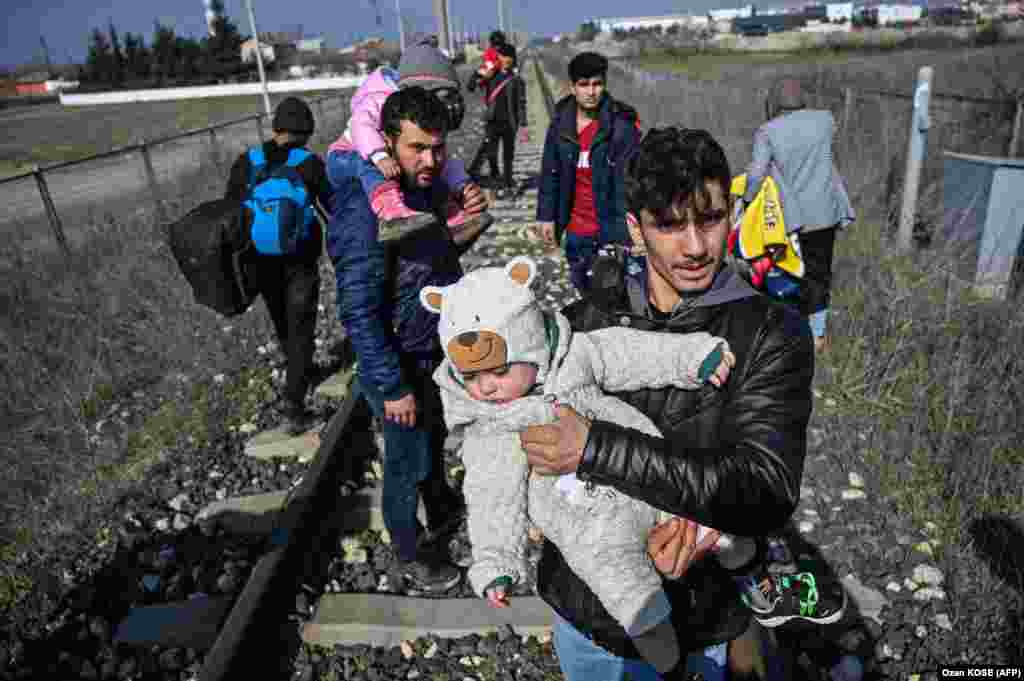 Migrant nosi svoju bebu dok korača željeznicom prema rijeci Meric, u blizini Edirnea, da bi se vozio čamcem za pokušaj ulaska u Grčku prelaskom rijeke 1. marta 2020. godine.