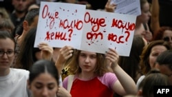 Жена държи плакат с надпис „Колко още?“ по време на демонстрация срещу домашното насилие в София, 31 юли 2023 г. 
