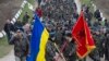 Українські вояки із прапорами і виконанням державного Гімну України на підході до російських військових, які відкрили попереджувальний вогонь. Крим, Бельбек, 4 березня 2014 року