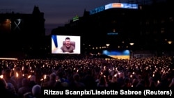 У центрі столиці Данії Копенгагені слухають і дивляться телезвернення президента України Володимира Зеленського (на екрані) до данського народу. Копенгаген, 4 травня 2022 року 