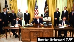 Dve verzije dokumenta, za kosovsku i srpsku stranu, pre godinu dana u Beloj kući, u prisustvu bivšeg američkog predsednika Donalda Trampa, potpisali su aktuelni predsednik Srbije Aleksandar Vučić i bivši kosovski premijer Avdulah Hoti, Vašington, SAD (4. septembar 2020.)