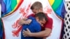 Сторонники брачного равноправия Колби Мелвин и Брэндон Браун обнимаются перед зданием Верховного суда США 