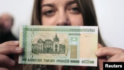 A woman holds a new 200,000 Belarusian ruble note (approximately $24.48) during a presentation to the media in Minsk on March 12.
