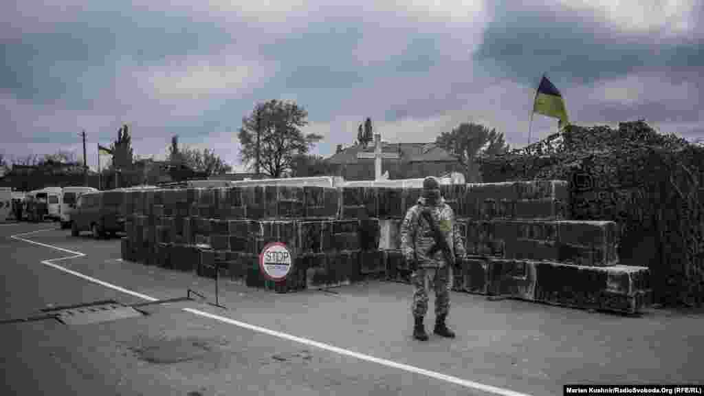 КПВВ Зайцеве. Прикордонник стоїть на в’їзді й регулює рух автомобілів, які направляються на непідконтрольну Києву територію Донбасу. В цей день контрольно-пропускний пункт в’їзду-виїзду перенесли на 20 кілометрів ближче до лінії розмежування