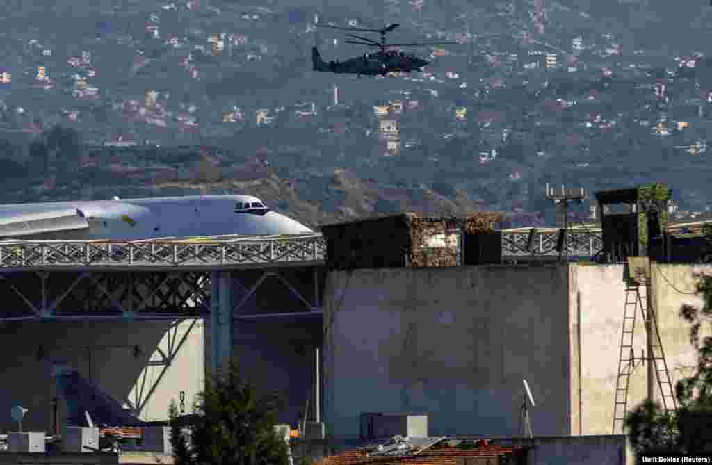 Ruski jurišni helikopter patrolira vazdušnom bazom Hmeimim. Bektas kaže da nije jasno hoće li ruske trupe koje pristižu u bazu Hmeimim s drugih položaja širom Sirije ostati tamo ili čekaju vazdušni transport iz Sirije.