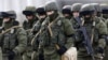 UKRAINE – Uniformed men, believed to be Russian servicemen, walk in formation near a Ukrainian military base in the village of Perevalnoye outside Simferopol, March 6, 2014