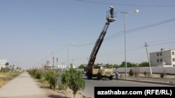 Illýustrasiýa suraty. Arhiwden alyndy. Elektrik üpjünçilik kärhanasynyň işgärleri elektrik sütünini gözden geçirýär. Balkanabat. 