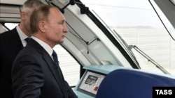 Russian President Vladimir Putin rides a train across the Kerch Bridge in December 2019.