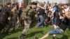 Человек в камуфляжной форме и папахе бьет участника акции "Он нам не царь" на Пушкинской площади в Москве, 5 мая 2018 года