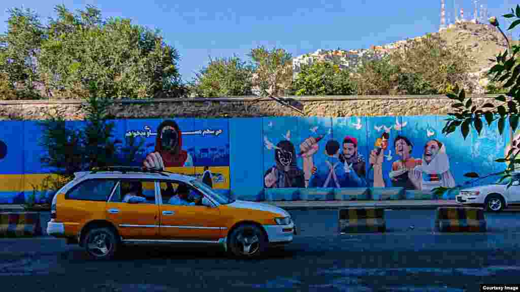 A mural promoting women&#39;s rights and a free press in Kabul with the females&#39; faces blotted out. Some defacing of images such as this are believed to have been done by locals who support the Taliban and their worldview.