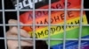 Aktivist za prava homoseksualaca drži poster s natpisom "Ljubav je jača od homofobije" u policijskom kombiju nakon pritvaranja na skupu u Moskvi, 2013. godina