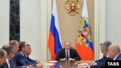 Russian President Vladimir Putin chairs a meeting with members of the Security Council to discuss additional security measures for Crimea on August 11.