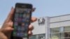 Na fotografiji snimljenoj 28. avgusta 2016. godine, žena drži svoj iPhone ispred zgrade u kojoj se nalazi izraelska grupa NSO, u Herzliji, blizu Tel Aviva.