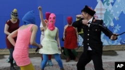 Russia -- Members of the punk group Pussy Riot, including Nadezhda Tolokonnikova in the blue balaclava and Maria Alekhina in the pink balaclava, are attacked by Cossack militia in Sochi, Russia, on Wednesday, Feb. 19, 2014. 
