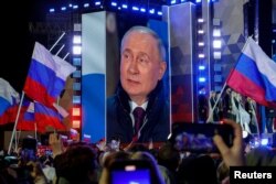 Ruski predsjednik Vladimir Putin pojavljuje se na ekranu pozornice dok prisustvuje skupu obilježavanja 10. godišnjice ruske nezakonite aneksije Krima od Ukrajine, na Crvenom trgu u centru Moskve 18. marta 2024.