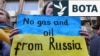 Një grua mban një pankartë gjatë një demonstrate në mbështetje të Ukrainës pranë Ambasadës Gjermane në Bruksel. (Fotografi nga arkivi)