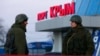 Вооруженные люди – по мнению почти всех, кроме Владимира Путина, российские военные, – в порту крымского города Керчь