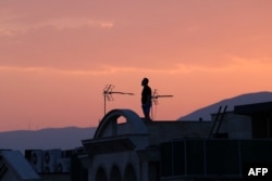Čovjek stoji na krovu zgrade dok posmatra horizont u Teheranu 16. juna. Iranski državni emiter je nakratko prestao s radom u izraelskom napadu, a eksplozije su odjekivale širom Teherana.