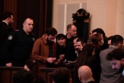 ადვოკატი ომარ ფურცელაძე ესაუბრება თავის დაცვის ქვეშ მყოფ დემონსტრანტს, გურამ მირცხულავას.