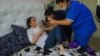 Medics examine Kazakh activist Saule Abildakhanqyzy after she said she was assaulted in Almaty on June 5. 