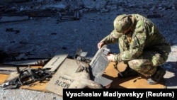 Policajac pregledava dijelove drona "shahed-136" na mjestu napada na skladišta goriva u Harkivu, 6. oktobra 2022.