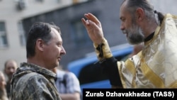 მოსკოვის საპატრიარქოს მღვდელი კურთხევას აძლევს პოლკოვნიკ იგორ გირკინს, 2014 წ.