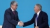 Kazakh interim President Qasym-Zhomart Toqaev (left) and former President Nursultan Nazarbaev shake hands at the congress of the ruling Nur Otan ruling party in Nur-Sultan on April 23. 