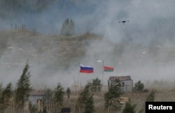 Steagurile rusești și belaruse flutură pe un teren de antrenament în timpul exercițiilor militare comune Rusia-Belarus „Zapad-2025” de lângă Borisov, Belarus, 15 septembrie 2025