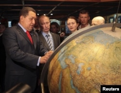 Российский премьер-министр Владимир Путин и президент Венесуэлы Уго Чавес осматривают земной шар во время посещения парусника российского флота Крузенштерн в порту Гуайра близ Каракаса, 2 апреля 2010 года