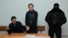 Aset Abishev (center) in court on November 30 