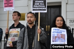 Supporters of Aron Atabek, including his son, Askar Aidarkhan (center), and wife, Zhainagul Aidarkhan, picket in front of the Kazakh Embassy in London in October 2012.