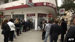 Очередь в банкоматы Laiki Bank, который подлежит реструктуризации согласно решению, принятому в ночь на субботу парламентом Кипра