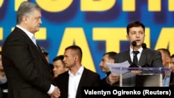 უკრაინის მეხუთე და მეექვსე პრეზიდენტები, პეტრო პოროშენკო (მარცხნივ) და ვოლოდიმირ ზლენსკი (მარჯვნივ) სპორტულ კომპლექს "ოლიმპიისკიზე" დებატების დროს. 2019 წლის აპრილი