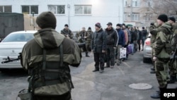 Ukrainian prisoners of war stand in line before their transportation to a place of exchange for pro-Russian rebels in Donetsk on December 26.