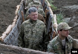 Ukrainian President Petro Poroshenko (center) examines fortifications and trenches not far from the eastern city of Mariupol on June 11.