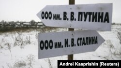 Росія. Вказівник в Алтайському краї в селі Горновка, який вказує, як дібратися до Товариства з обмеженою відповідальністю імені В.В. Путіна. А інший вказівник вказує напрямок до ТОВ імені Й.В. Сталіна. Село Горновка (архівне фото) 
