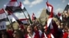 Egypt -- Egyptian tour guides wave their national flag as they urge tourists to return to the country following the fall of Mubarak's regime at the Giza pyramids on the outskirts of Cairo, 14Feb2011